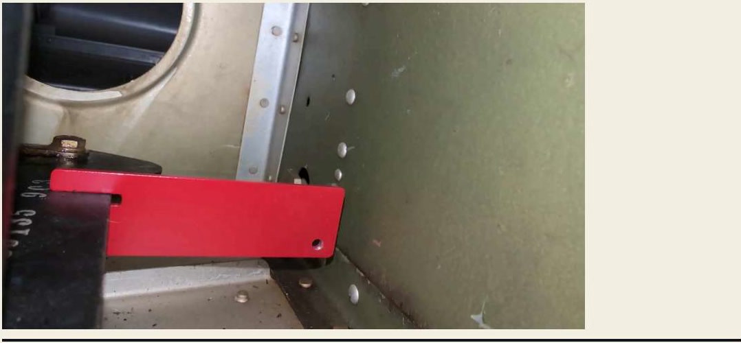 The bellcrank rigging tool blocks the forward portion of the bellcrank against the nearest rib.