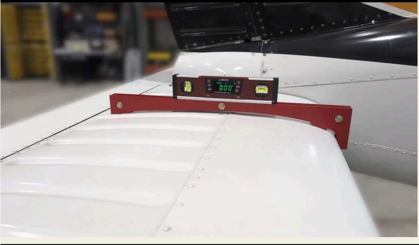 The stabilator tool rests against the leading edge and on top of the stabilator at the inboard edge of the fairing.